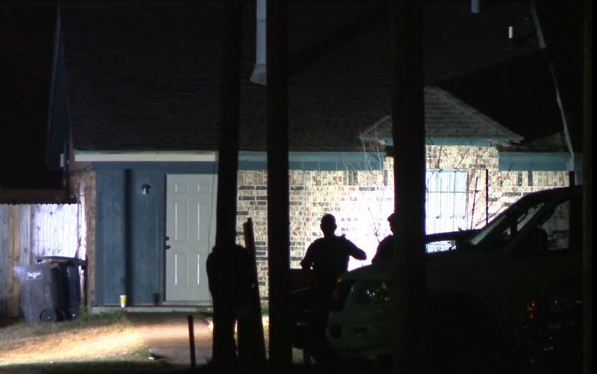 Fort Worth police officers keep an eye on a home after a man was shot in the area Monday...
