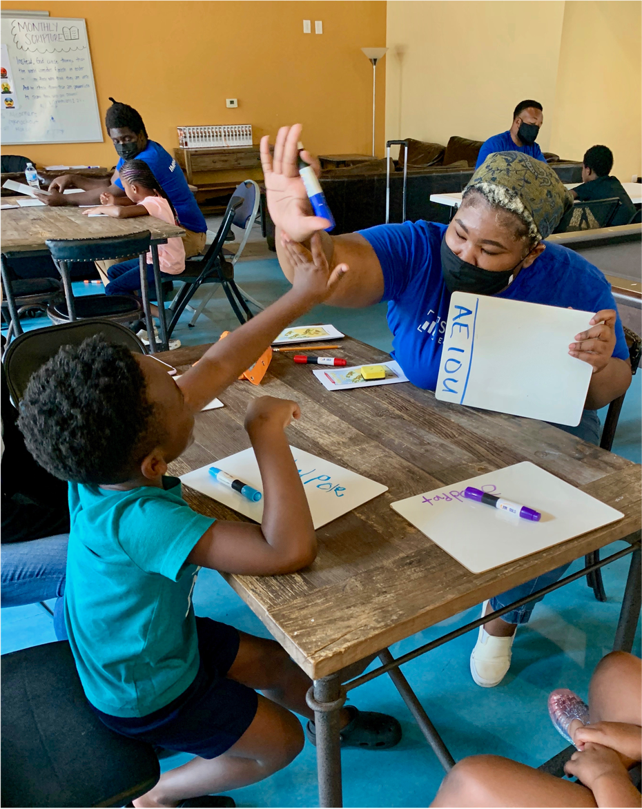 Kiera, an instructor, high-fives a student during a lesson through Dallas Afterschool.