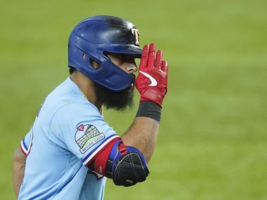 Texas Rangers second baseman Rougned Odor salutes third base coach Tony Beasley as he rounds the bases after hitting a solo home run during the fifth inning against the Houston Astros at Globe Life Field on Sunday, Sept. 27, 2020.