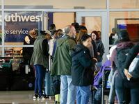 People wait in line outside a Southwest Airlines baggage service office at Dallas Love Field...