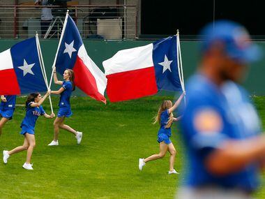 The Rangers Texas flag bearers race around the grassy knoll after Delino DeShields scored...