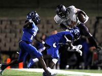 West Mesquite's Canaan Dirden (44) is knocked off his feet by North Mesquite defensive back...
