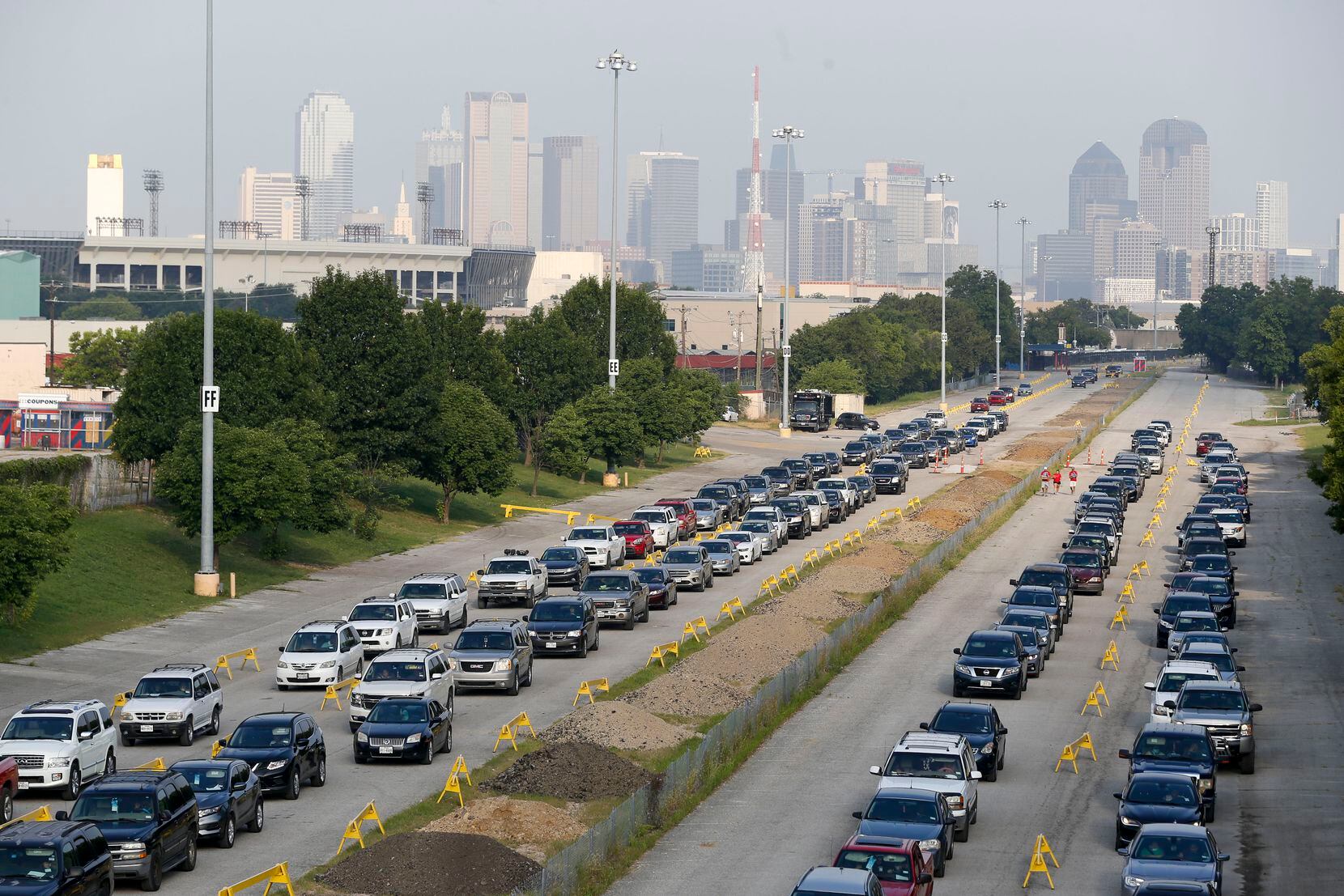 Cars wait to receive school supplies during the mayor’s back to school fair at Fair Park on...
