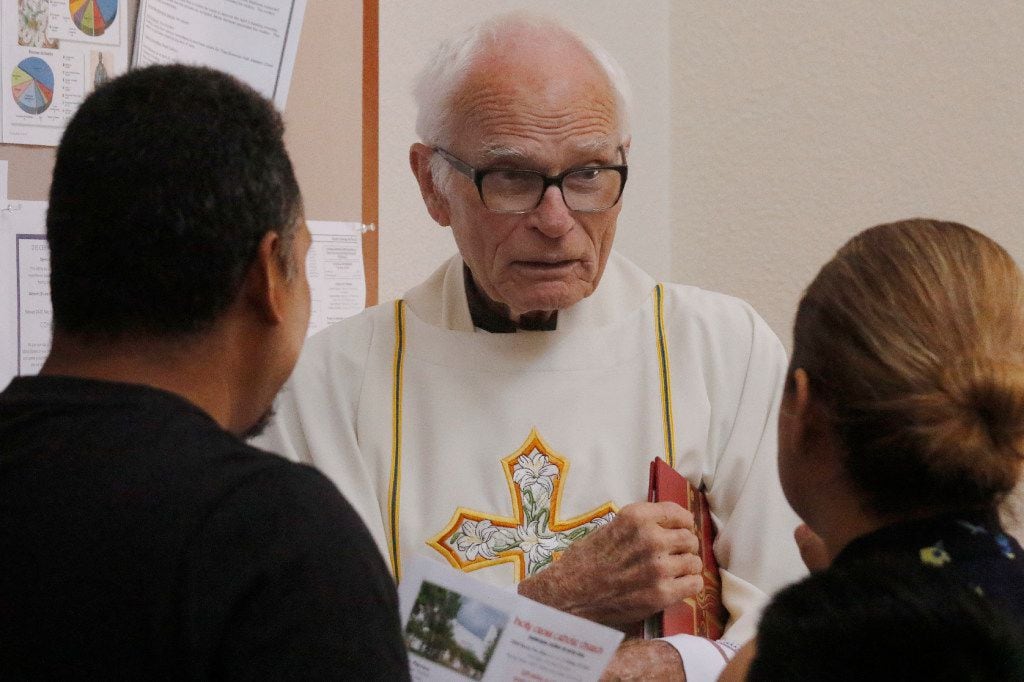 The Rev. Tim Gollob visits with parishioners after Mass at Holy Cross Catholic Church. He...