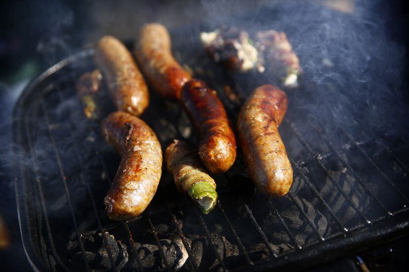 Bratwurst sizzles on a grill.