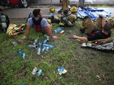 Firefighters rest while battling flames at Goff's Hamburgers in Dallas on Aug. 12, 2016....