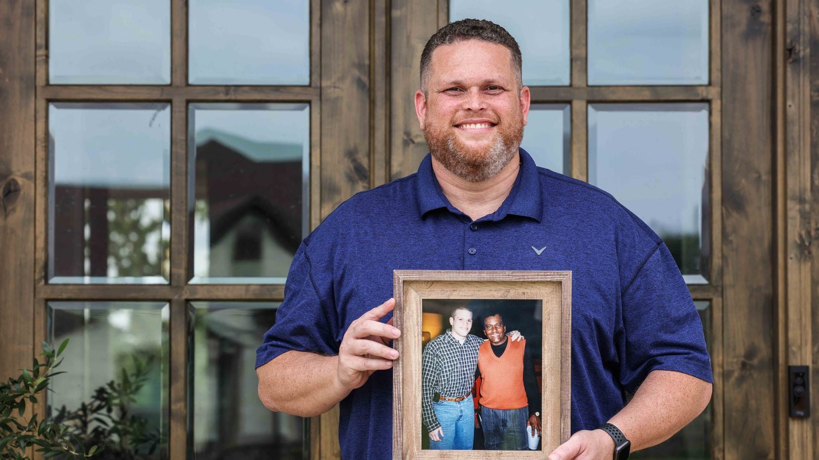Tyler Tines Pride poses for a portrait in front of his home in Lindale as he holds a photo...