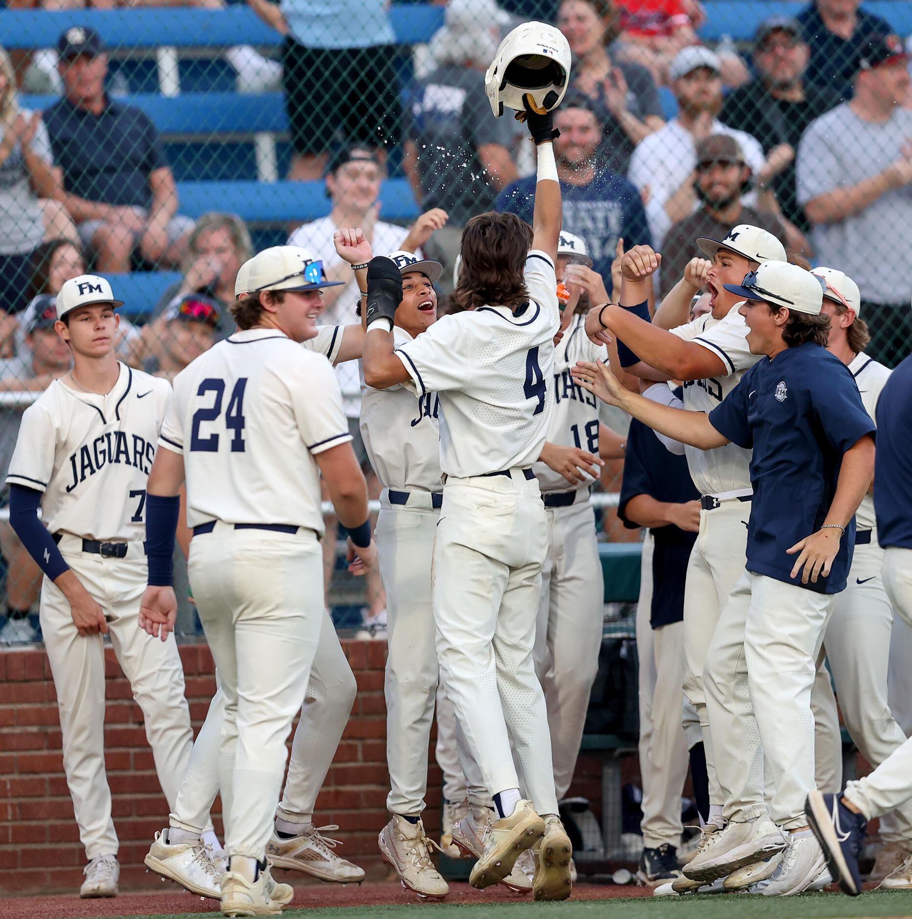 Flower Mound shortstop Ryder McDaniel (4) celebrates with his teammates after scoring a run...