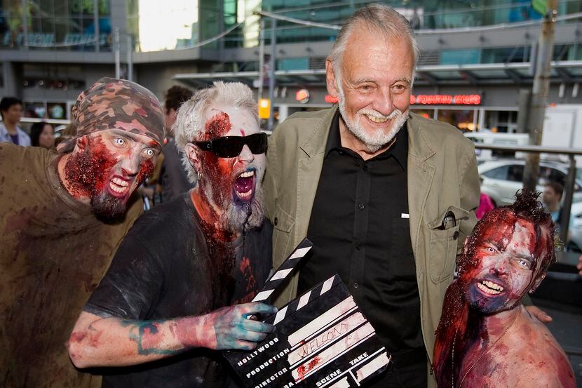 El director de cine George A. Romero pose junto a fans de sus películas de zombies en el...