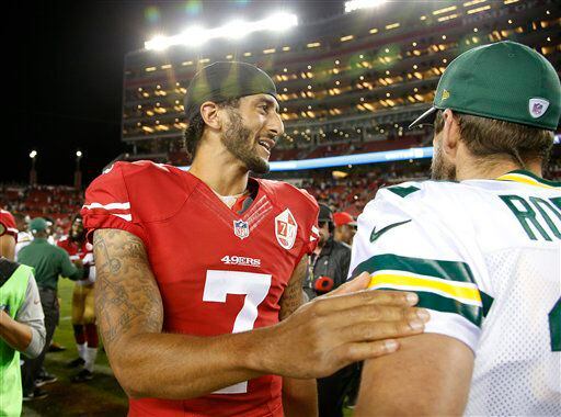 El quarterback Colin Kaepernick, de los 49ers de San Francisco, a la izquierda, saluda al...