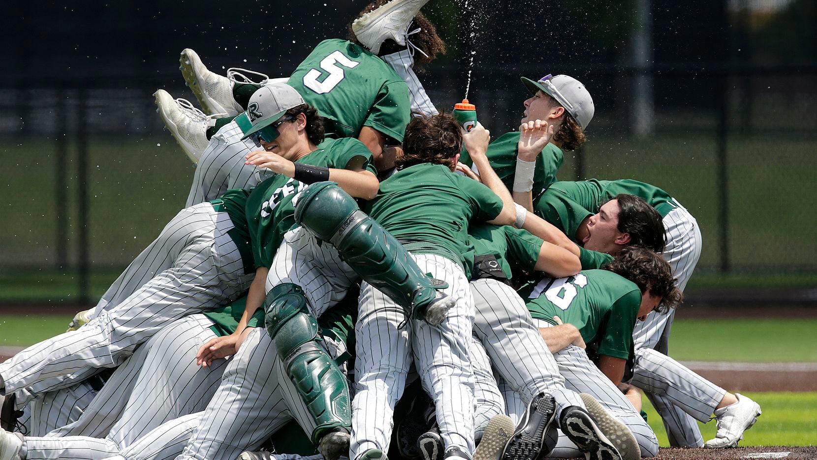 Team mates pile onto Reedy High School pitcher Jack Jorgenson (10) on the mound after he...