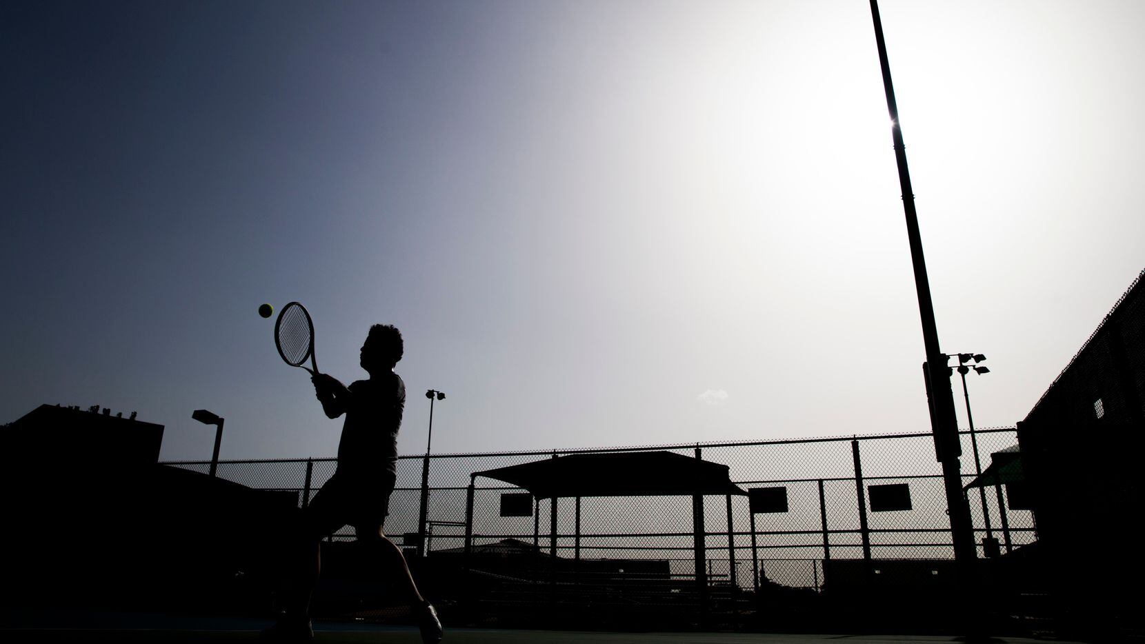 Antonio Sosa works on his backhand during a tennis lesson in 104 degree heat on Tuesday,...