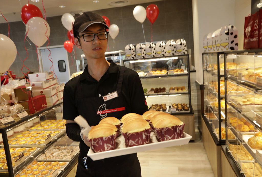 Tei Wei Chu stocks the pastry shelves during the opening of 85°C Bakery Cafe in Frisco.