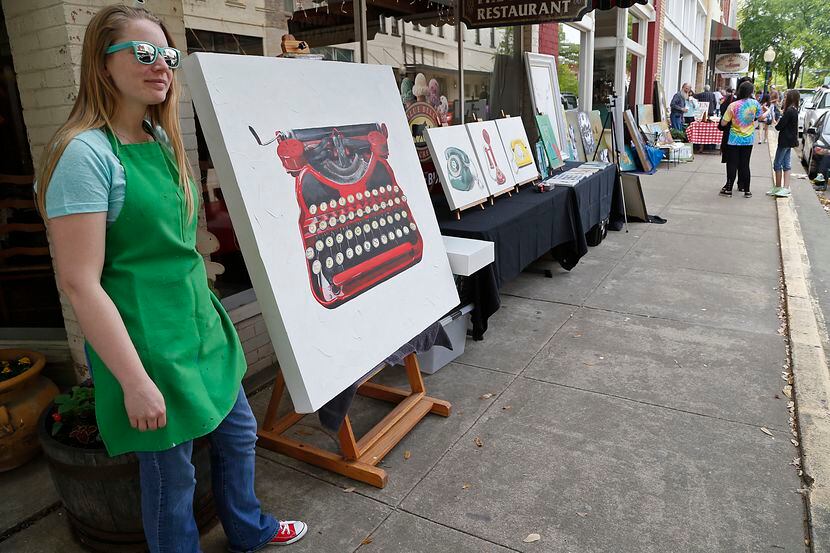 Artist Andrea Holmes of Anna stands with her work on a sidewalk in downtown McKinney during...
