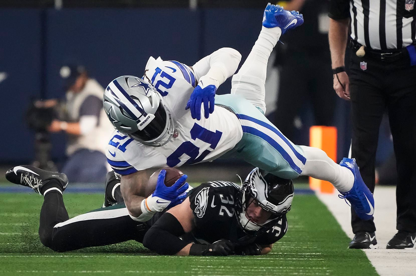 Dallas Cowboys running back Ezekiel Elliott (21) is knocked off his feet by Philadelphia...