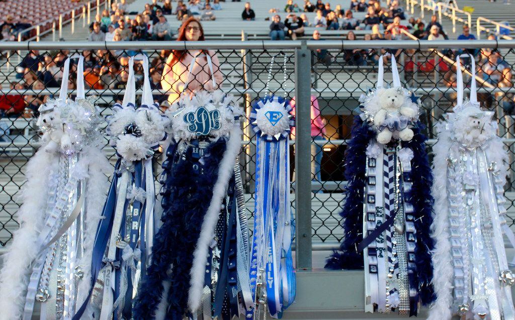 Giant mums hang on a fence during Wylie East's homecoming before the start of the Mesquite...