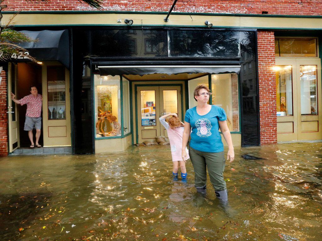 Majka Woods (right) and her daughter Anneli Kucera play in the flooded sidewalk as Tim...