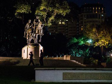 Police officers patrol the area around a statue of Robert E. Lee around 10:30 p.m. on...