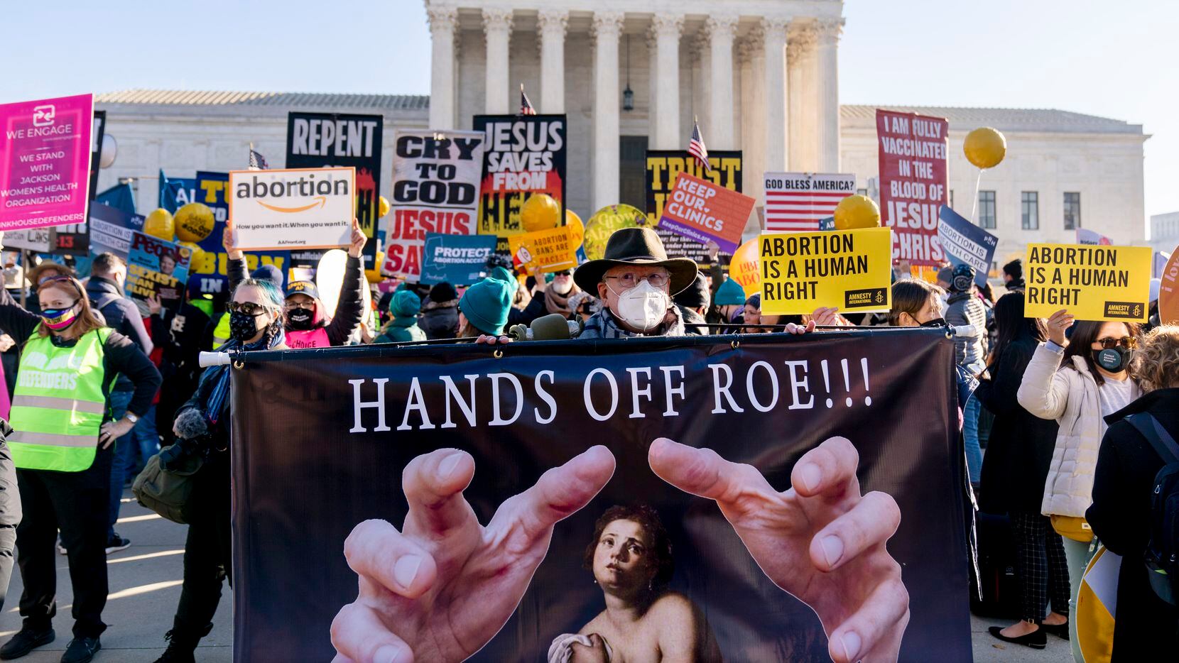 Stephen Parlato of Boulder, Colo., holds a sign that reads "Hands Off Roe!!!" as abortion...
