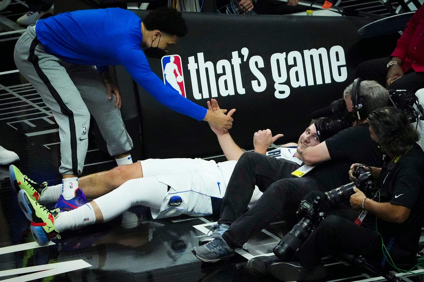 Dallas Mavericks guard Luka Doncic gives a thumbs up after tumbling out of bounds during the...