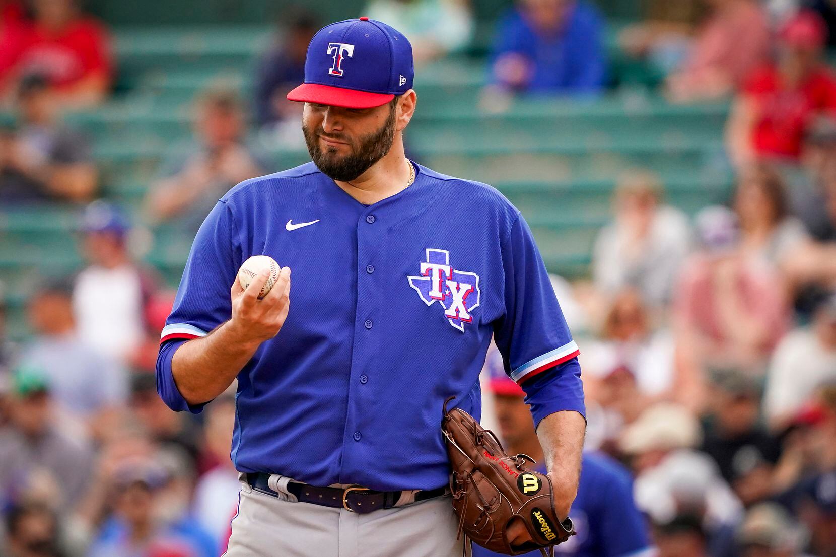 Texas Rangers pitcher Lance Lynn gets a new ball after giving up a run on a single by Los...