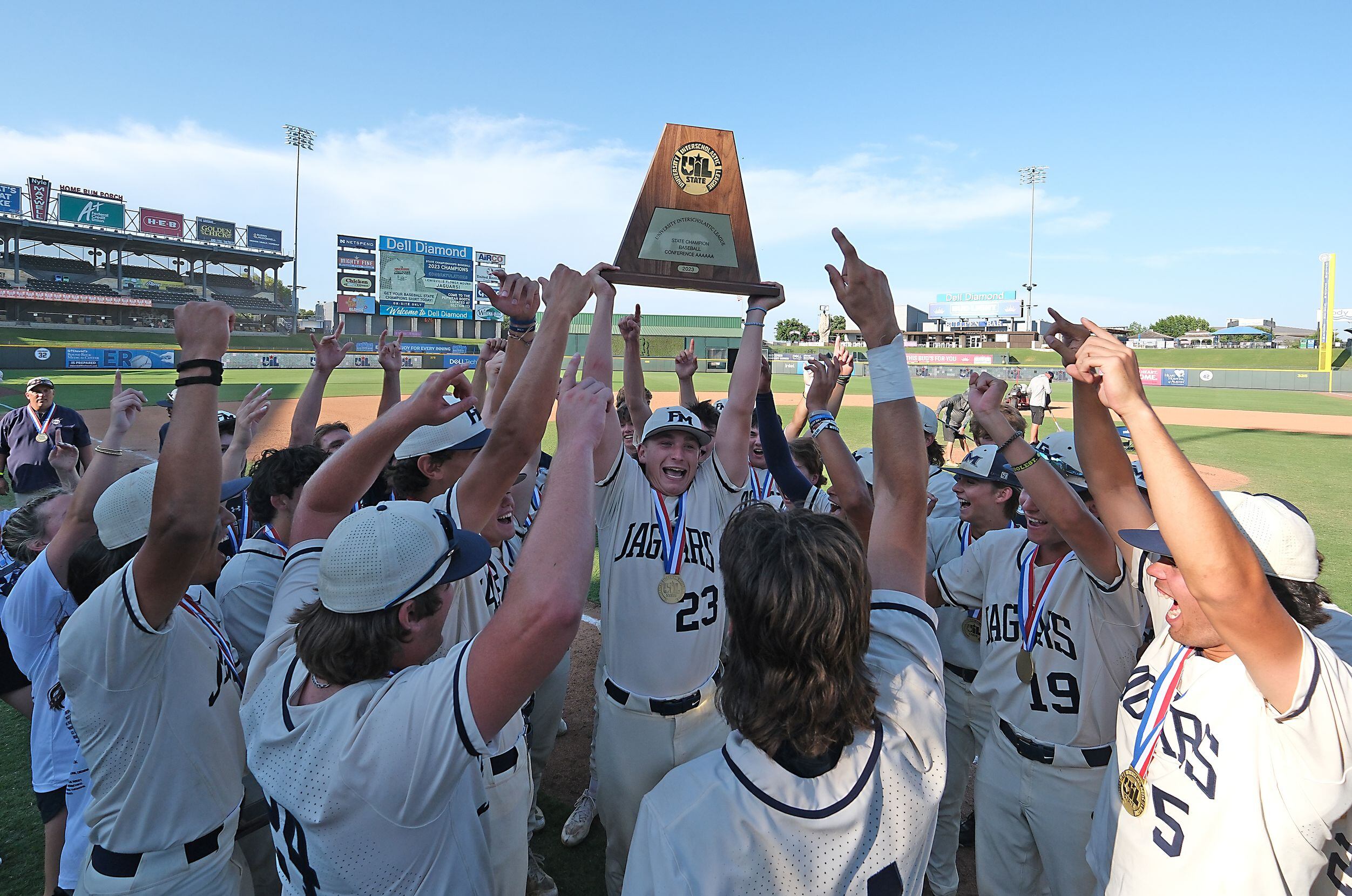 Flower Mound Mason Arnold, (23), and the team celebrate with the championship trophy after...