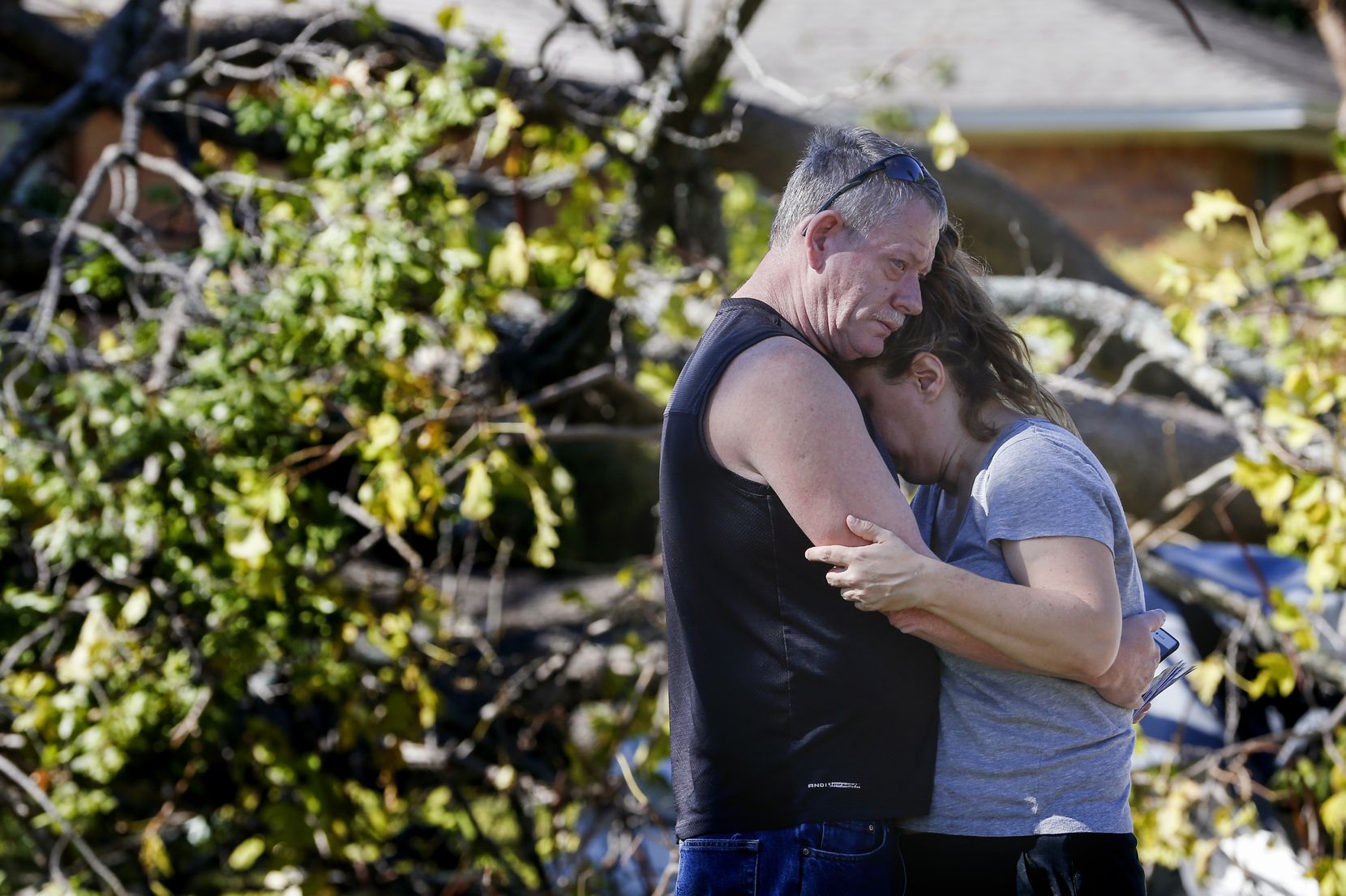 Tommy Edmonds, left, embraces his wife, Heidi Edmonds, outside of their home, which was...