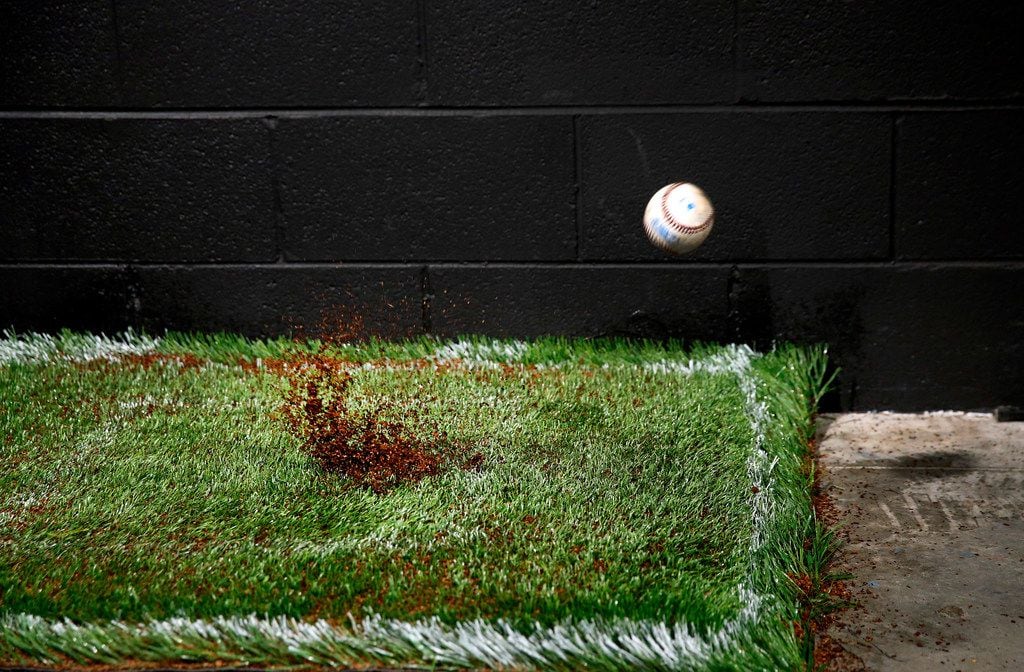 A baseball is fired at 85-100 mph at a turf sample in the Shaw Sports Turf's indoor...