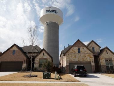 A McKinney water tower looms behind new homes in the 100 block of Leadville Way in McKinney,...