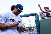Dallas Cowboys linebacker Eric Kendricks smiles as he gives autographs to young fans during...