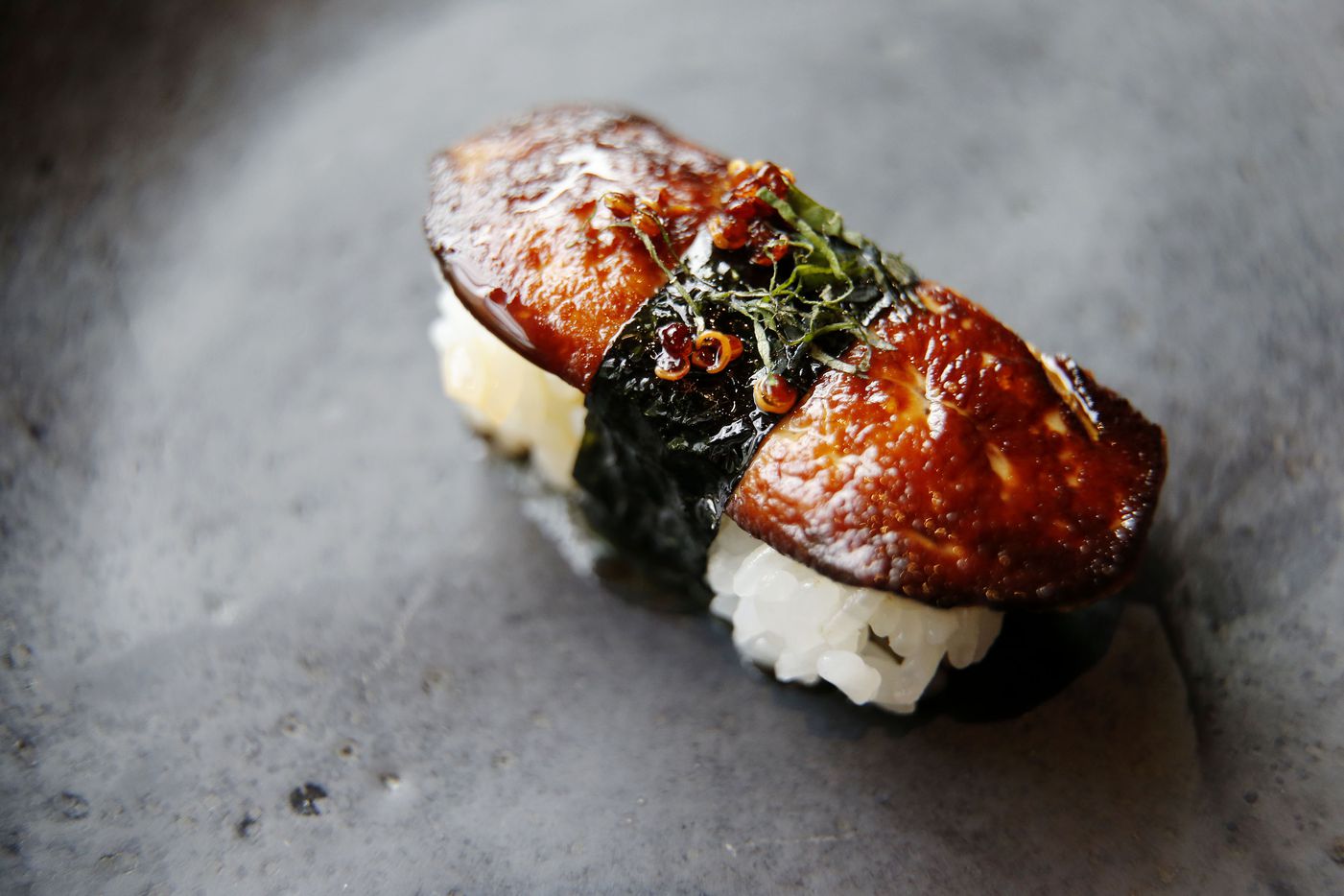 Foie gras nigiri sushi. The seared foie is brushed with fish caramel, banded with nori and...