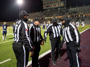 Referees confer after a controversial play in the end zone in the first half of a high...