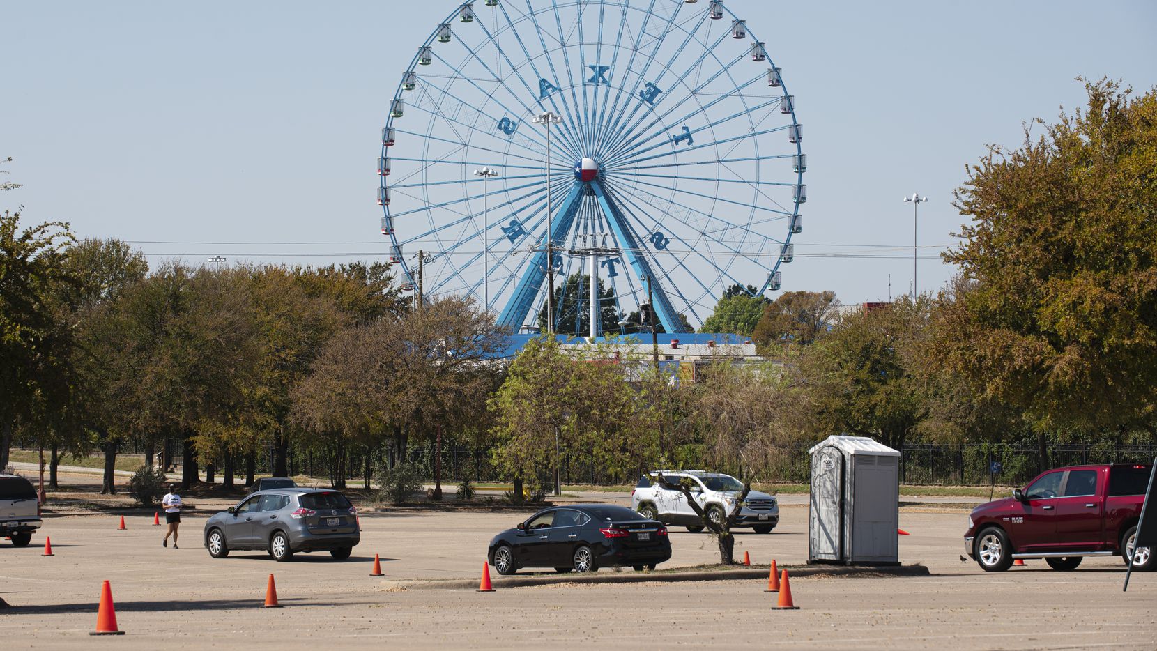 A few vehicles move toward the entrance of the State Fair of Texas Drive-Thru at Fair Park...