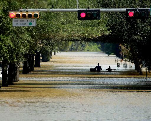 Unas personas son evacuadas de un vecindario inundado por las aguas de la reserva Addicks,...
