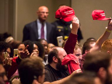Supporters hold up Donald Trump "Make America Great Again" hats as Richard Spencer speaks. 