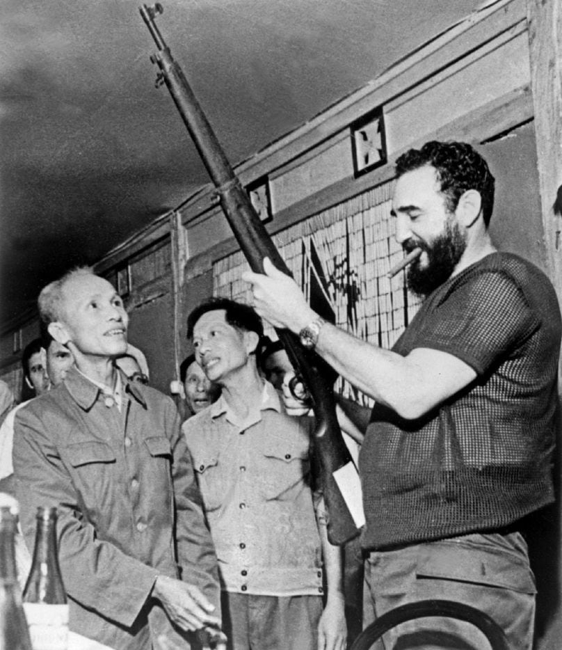 In this Sept. 1973 file photo, Cuban president Fidel Castro (R) looks at a rifle during a...