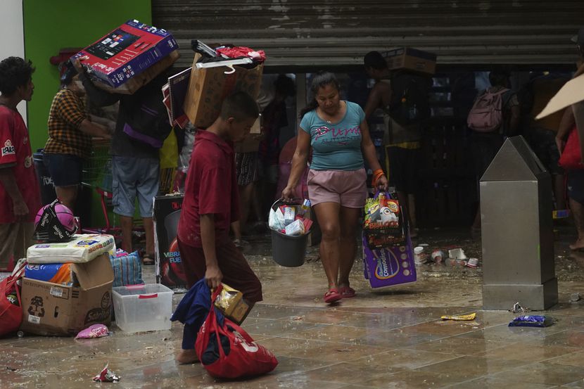 Varias personas saquean una tienda de comestibles luego del paso del huracán Otis por...