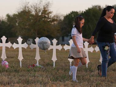 Eight-year-old Heather Cooper and her mother, Meredith Cooper, of San Antonio walk away...