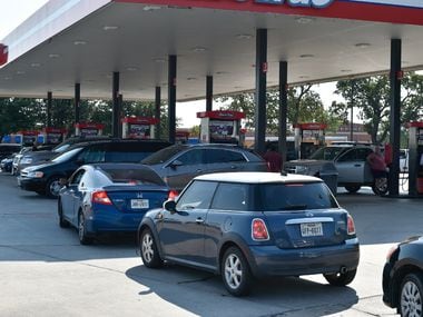 Locals wait in line to fill up their vehicles with gas at a RaceTrac near South Loop 288 and...
