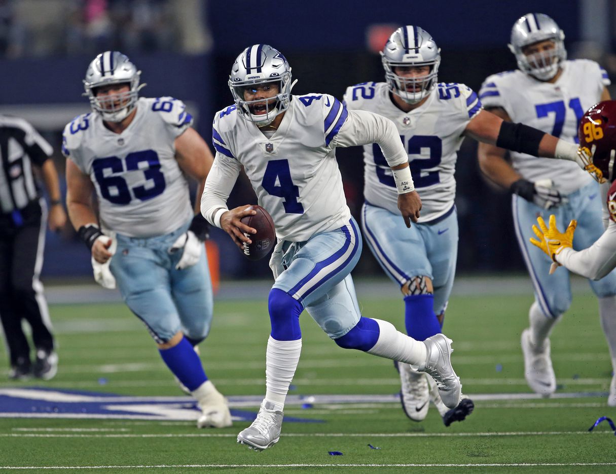 Dallas Cowboys quarterback Dak Prescott (4) scrambles for a first down during the first half of a NFL football game against the Washington Football Team at AT&T Stadium in Arlington, TX on Sunday, December 26, 2021.