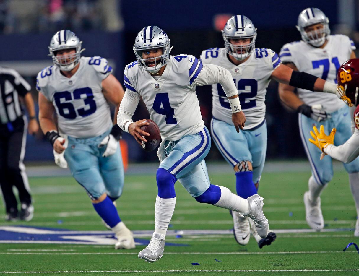 Dallas Cowboys quarterback Dak Prescott (4) scrambles for a first down during the first half of a NFL football game against the Washington Football Team at AT&T Stadium in Arlington, TX on Sunday, December 26, 2021.