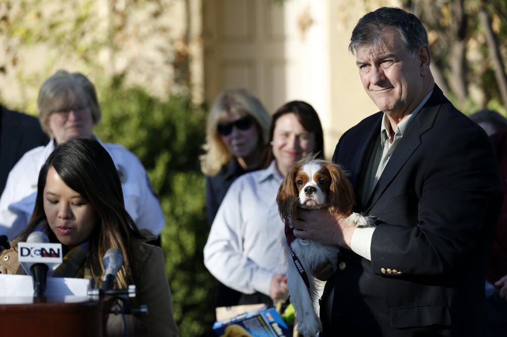 Dallas Mayor Mike Rawlings holds Bentley as Dallas nurse Nina Pham speaks to the media after Pham and Bentley were reunited following the canine finishing a 21-day monitoring period for the Ebola virus at Hensley Field in Grand Prairie on Nov. 1, 2014. Pham was cured of Ebola at the National Institute of Health in Maryland.