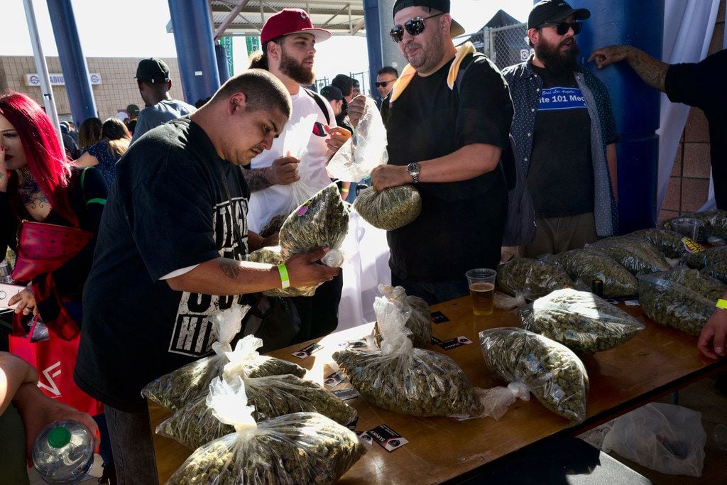Customers survey a selection of marijuana in large plastic bags at the cannabis-themed...