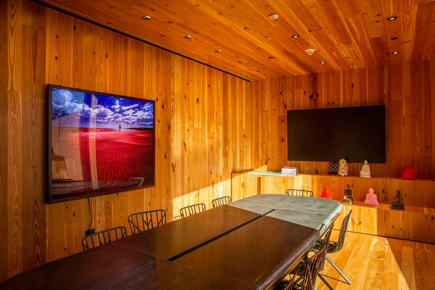 A wood-paneled conference room features a one-ton concrete meeting table and chairs designed...