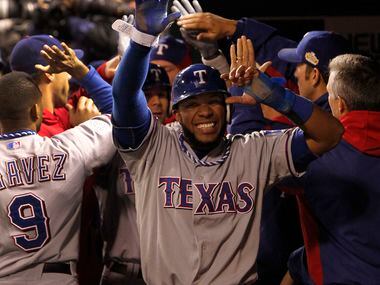 texas SS Elvis Andrus is all smiles as teammates congratulate him in the dugout after he...