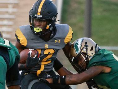 St. Frances Academy Kevyn Humes (12) is stopped by DeSoto High School Keshaun Jackson (10)...