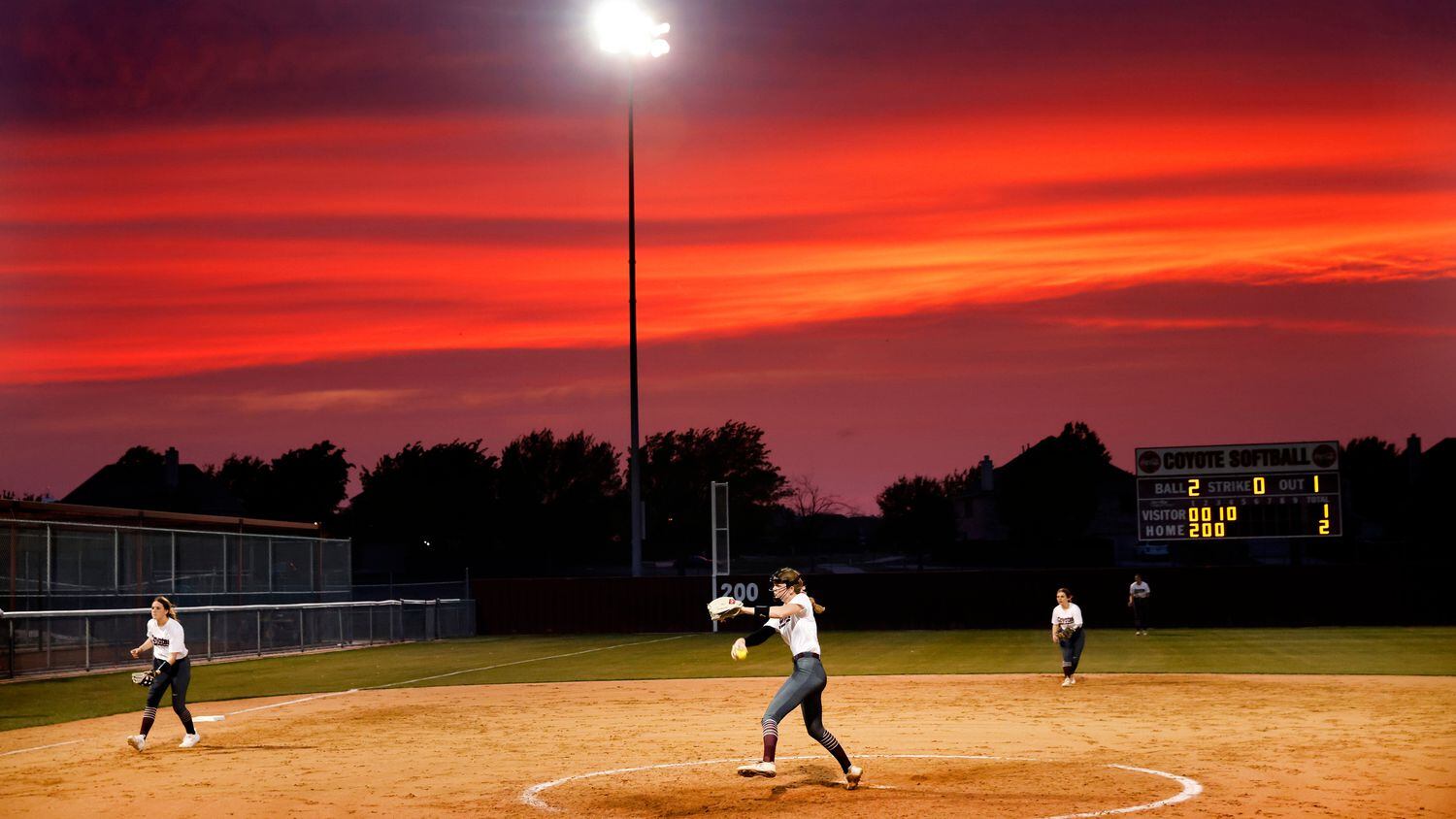 Before the setting sun, Frisco Heritage starting pitcher Jensin Hall throws a pitch to...