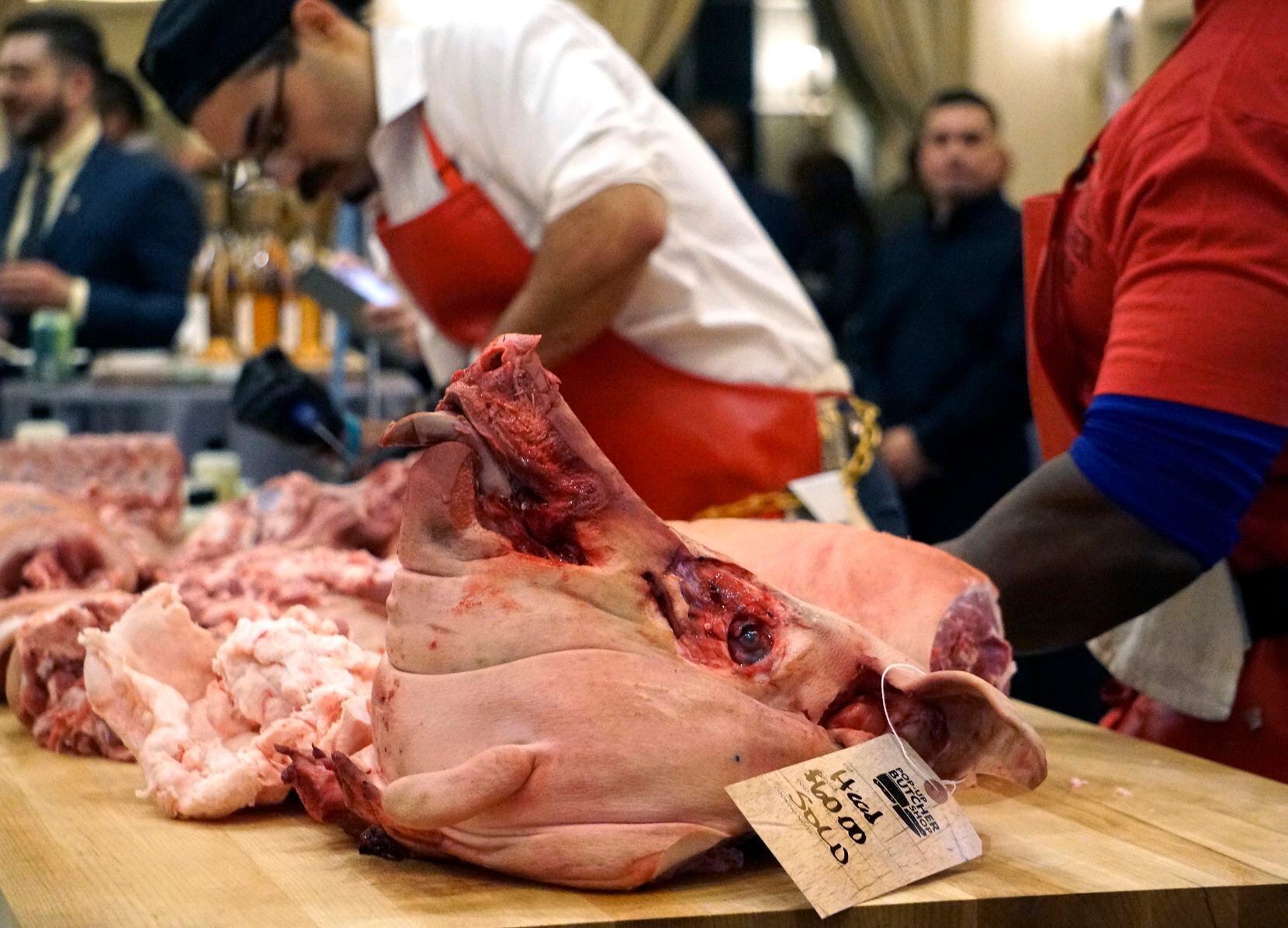 Local butchers cut up a pig during a fundraiser at Cochon555 at the Four Seasons Hotel in...