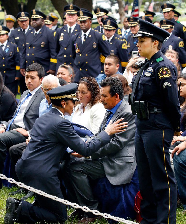 Dallas Police Chief U. Renee Hall hands a folded flag to Rogelio Santander Sr., father of...