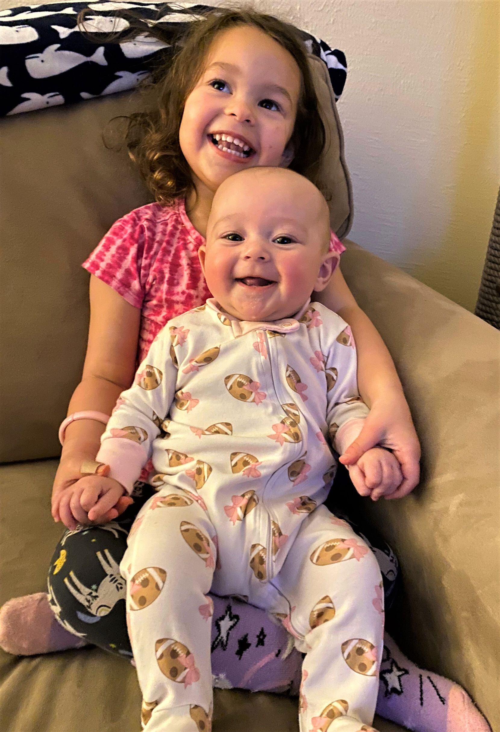 Oh, baby, the Cowboys have been good this season! And Christina Goldberg hopes that with little daughter Claire Goldberg safely snuggled up in her lucky football onesie, the team can squeak out another victory Sunday to keep their season alive. That would give the whole family, including older sister Meg, something to really smile about!